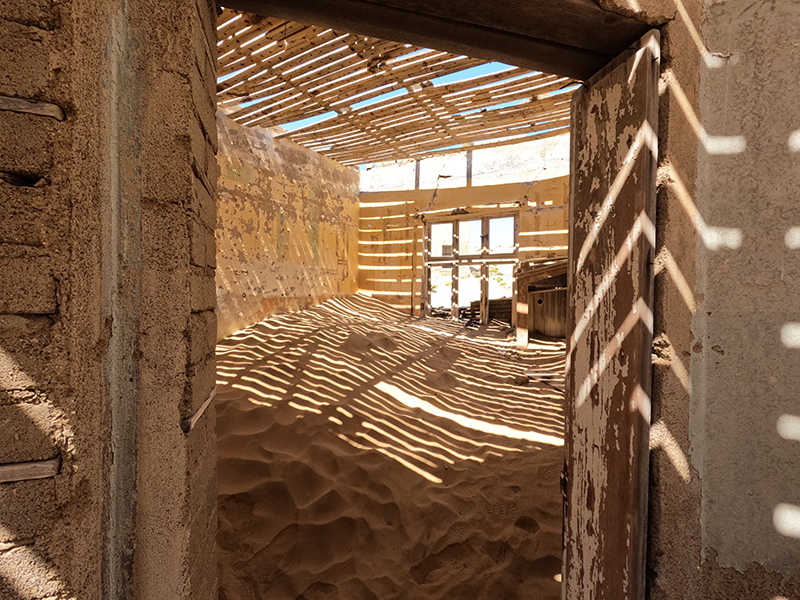 Sand-filled room inside an abandoned house at Kolmanskop, Namibia