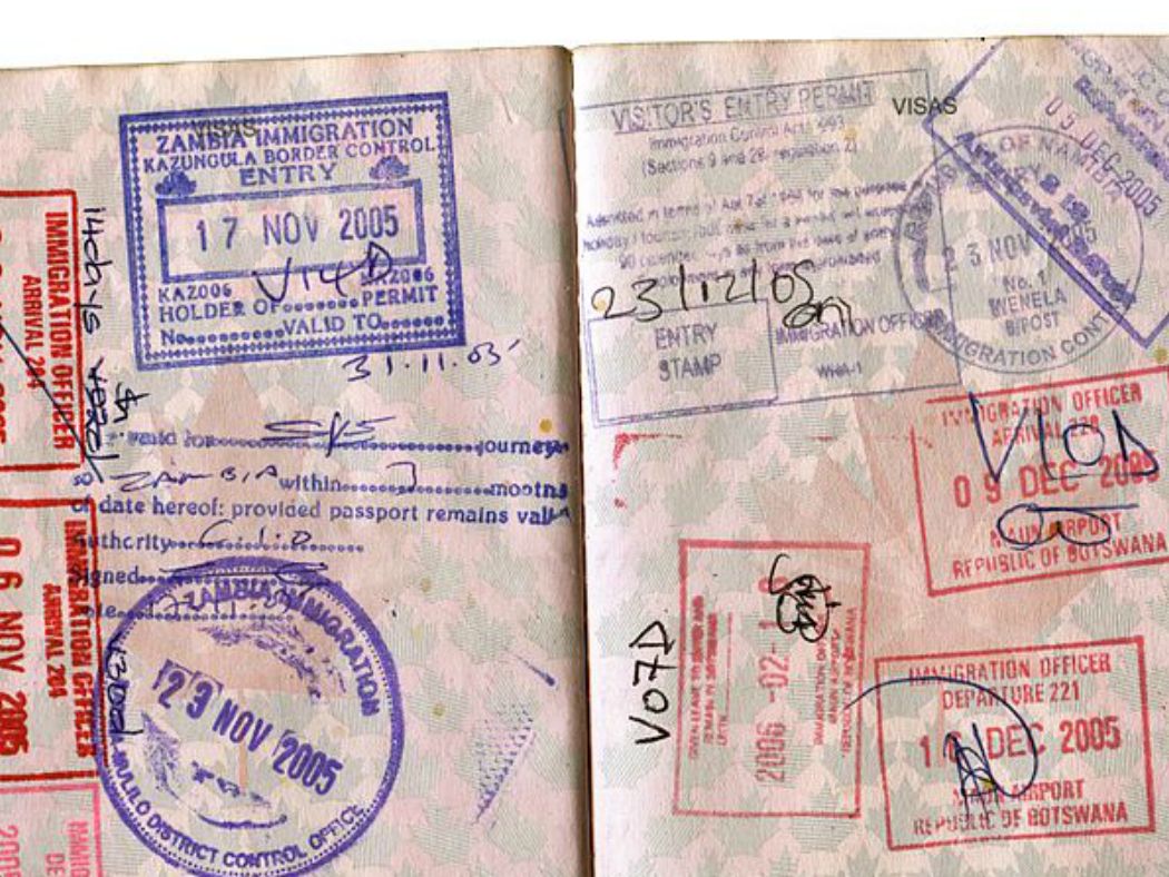 A passport open to pages of entry stamps