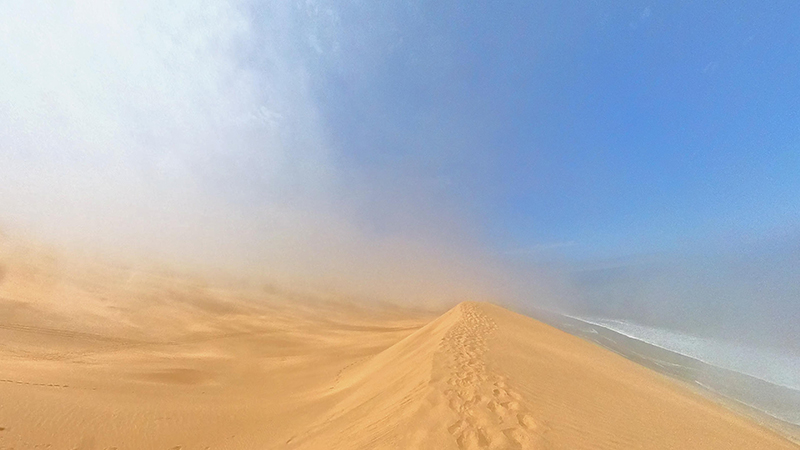 Coastal fog rolling over the dunes near Sandwich Harbour on a summer morning