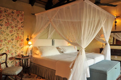 Spacious Luxury Chalet room at Epacha Game Lodge, Aus, Namibia, featuring a king-size bed with a mosquito net, combining comfort with safari-inspired elegance.