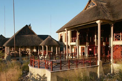 Image showcasing a portion of Epacha Game Lodge, highlighting its luxurious thatched design and surrounding lapas. Aus, Namibia