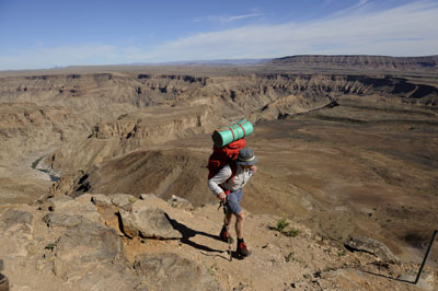 Fish River Canyon Hiker with backpack at the top of Fish River Coanyon before decending
